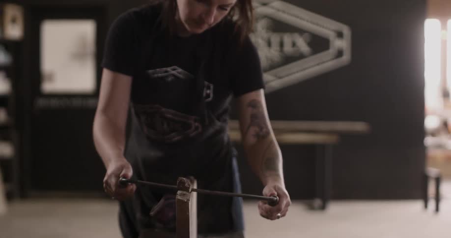 A woman is cutting wood with a hand saw