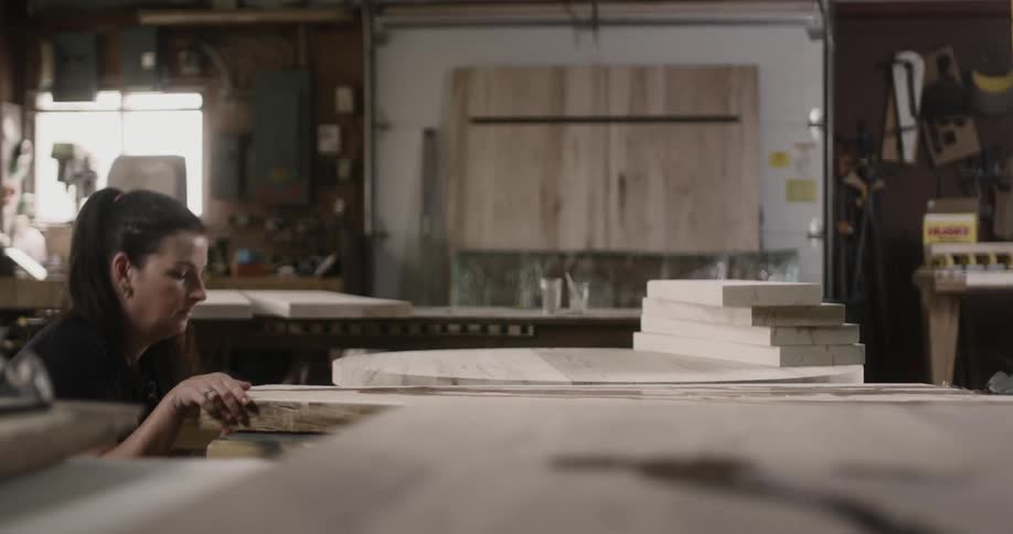 A woman looks at pieces of wood