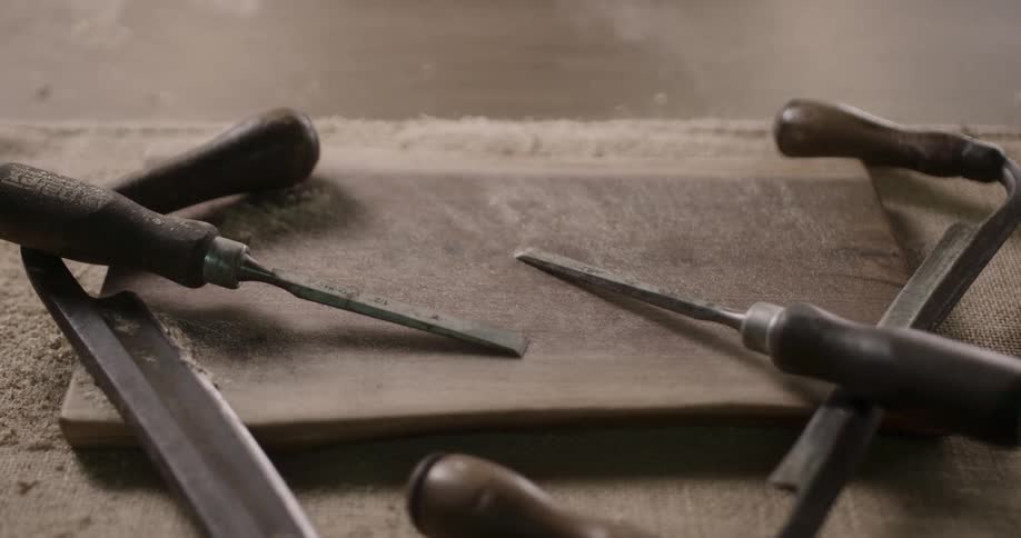 Sawdust on a set of chisels being blown away by a gust of wind