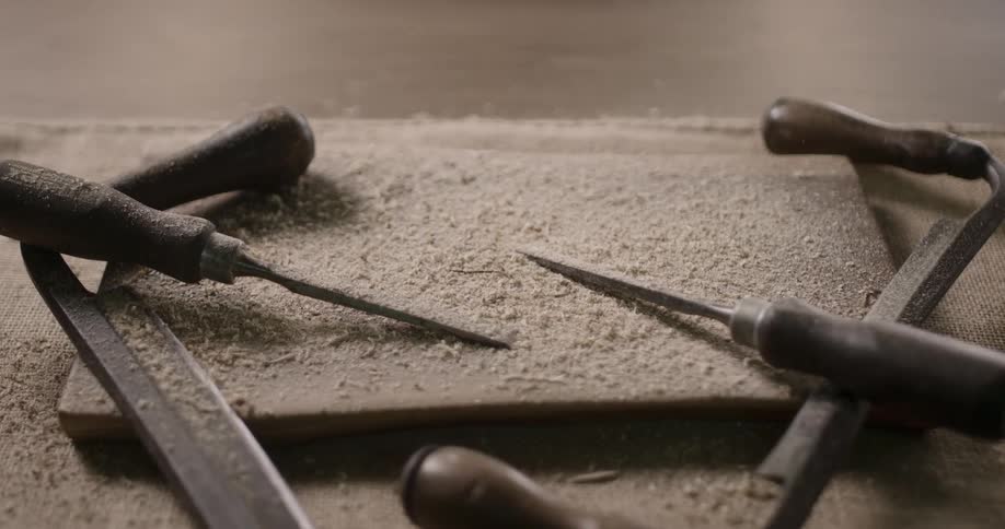 Wood dust is being dropped on screwdrivers on the table during daylight