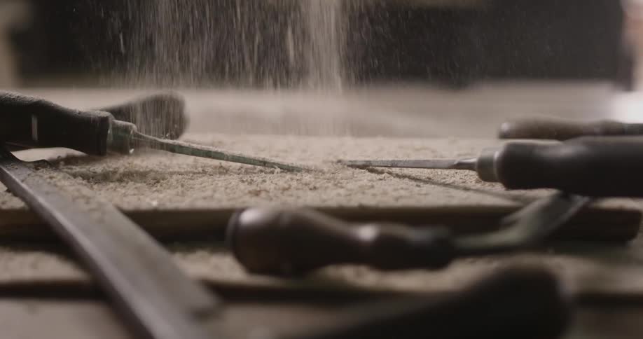 Sawdust falls onto tools rested on a table