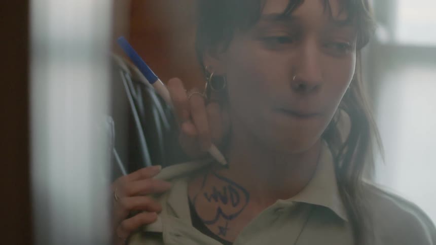 Person sketches tattoo with marker on womans neck