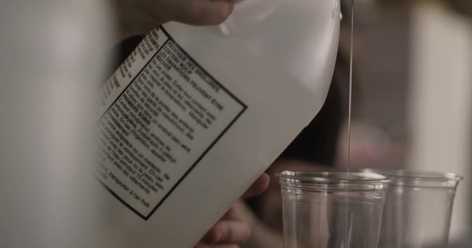 A person pours a thick liquid into a cup