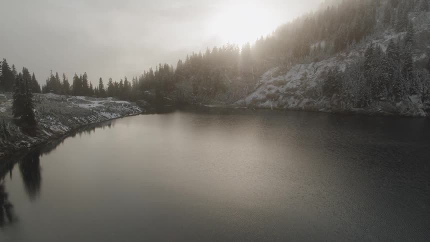 A lake sits in a mountain valley during winter