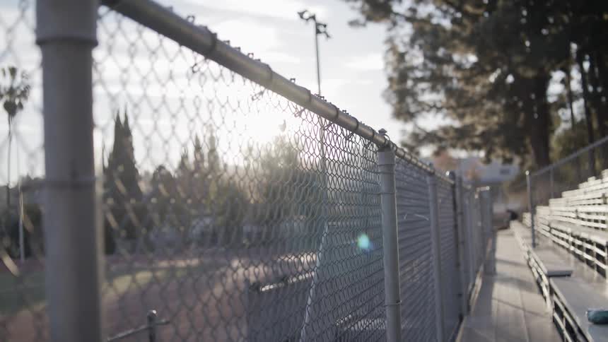 A fence surrounds the front part of bleachers at a stadium