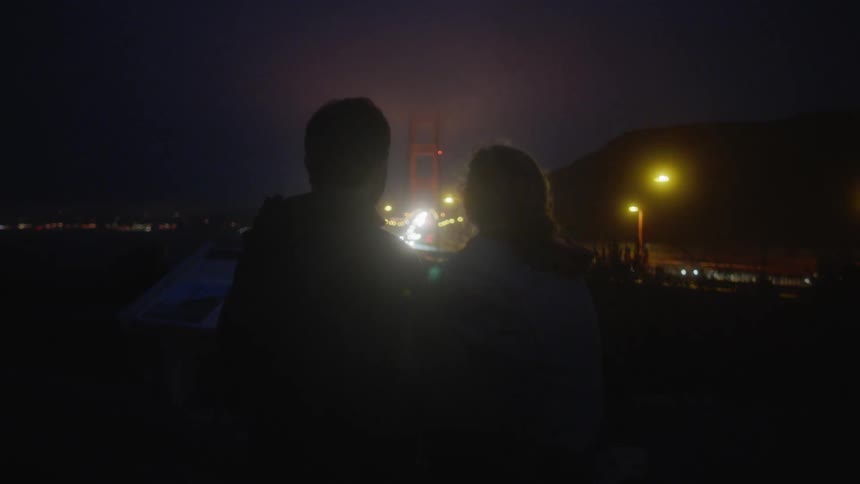 A couple sit and look at the skyline