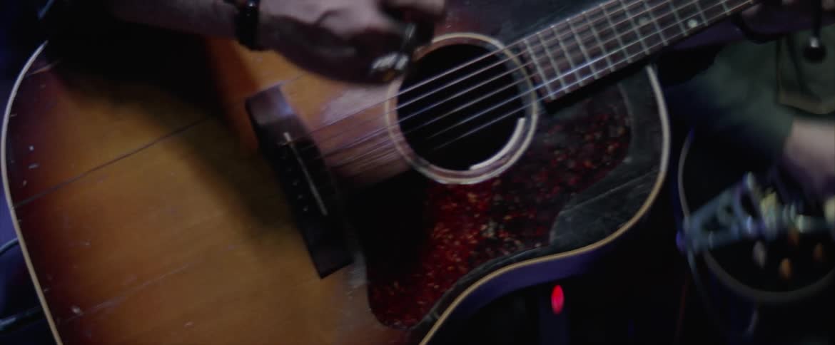 Guitarist strumming on an acoustic guitar