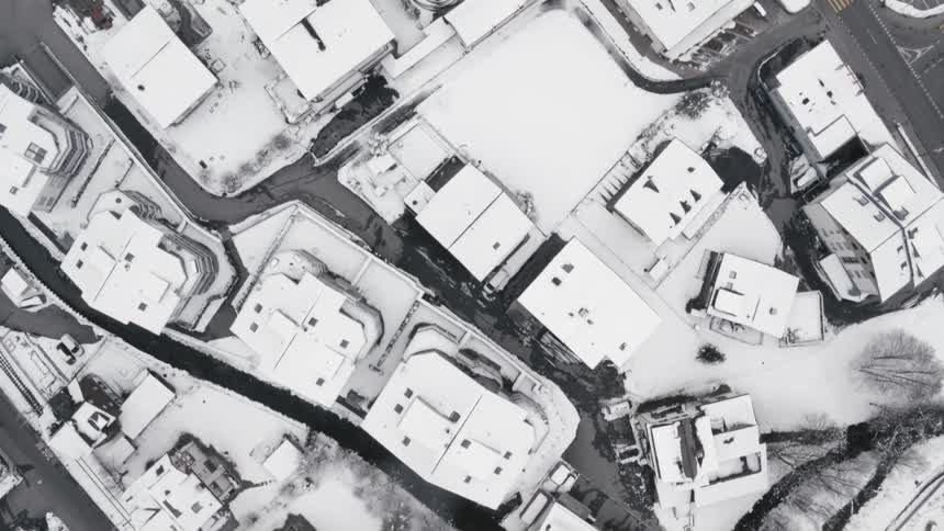 A city with buildings and roads covered in snow