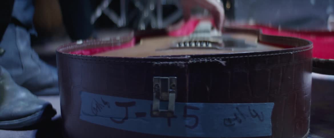 A guitar being picked up out of a case