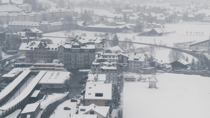 Snow falling on a european town during the day