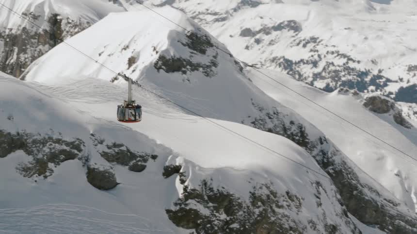 A gondola lift ascending a mountain ridge