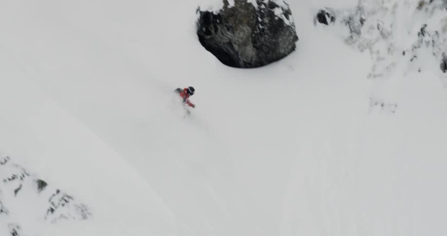 A man is downhill skiing outdoors