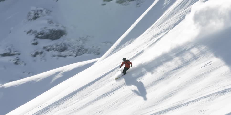 Man skis down a snow covered mountain