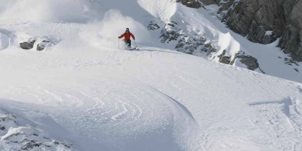 A skier goes down a snowy mountain