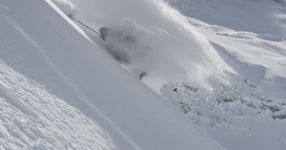 A skier skiing down a steep slope