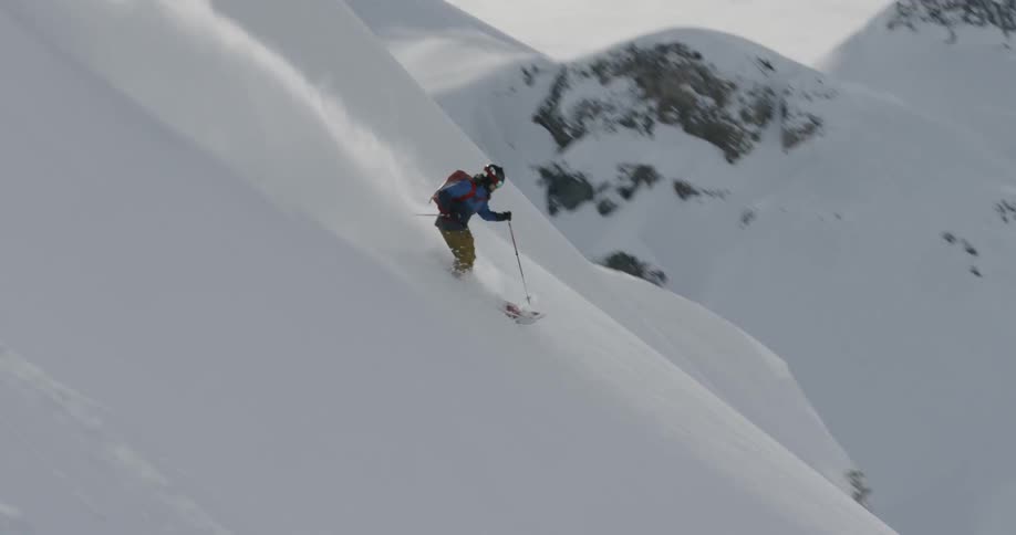 A person skiing down a mountain in the snow
