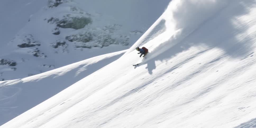 Skier skis down the hill on a sunny winter day