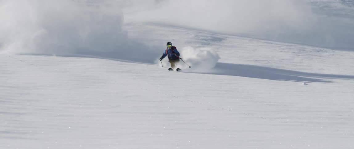 A skier races down a slope covered in deep snow