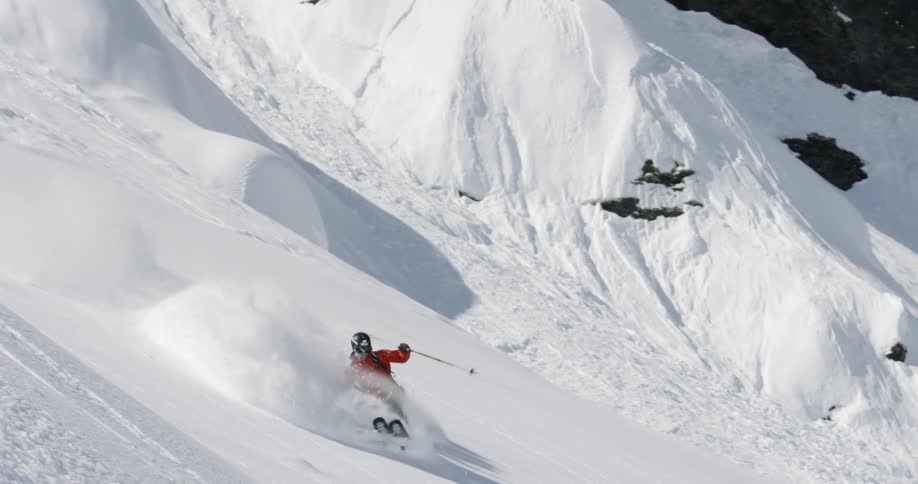 A person skiing down a mountain starts to fall and loose control