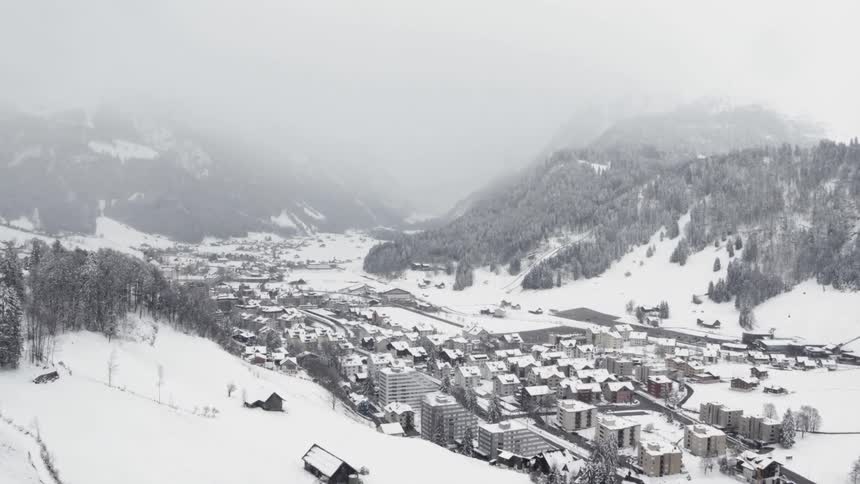 An aerial view of a town surrounded by snowy mountains