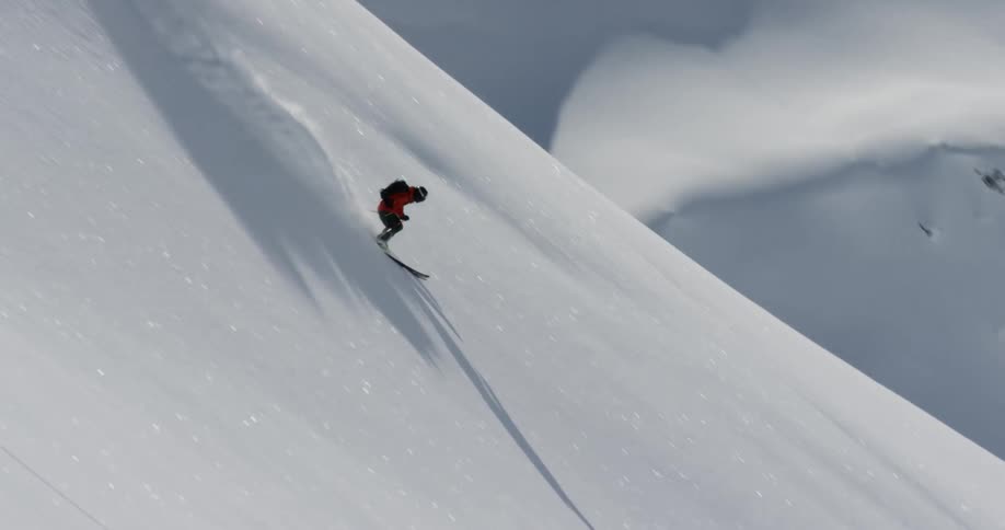 Extreme sports skier is making their way through the snow on the slope of a mountain