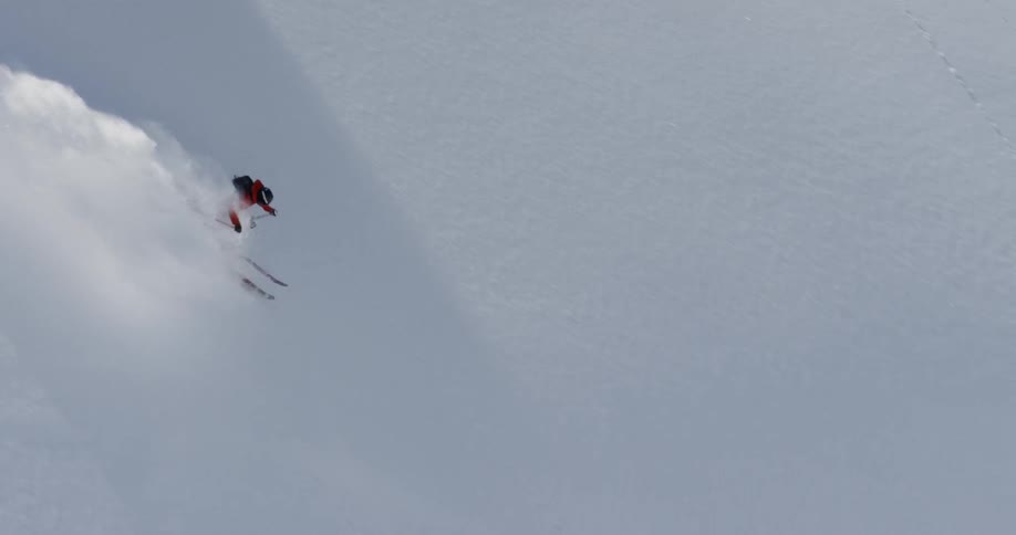 A person skiing loses control and flips forward in the snow