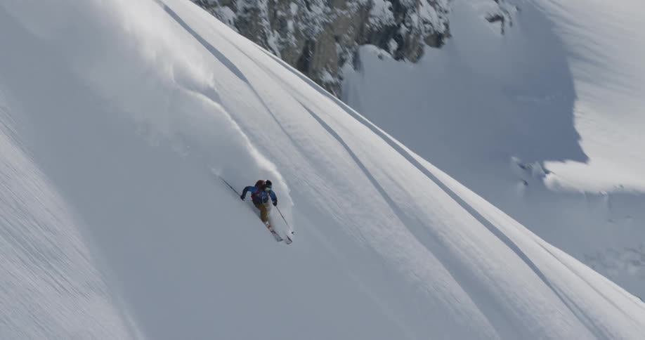 A person is skiing down a snowcovered mountain