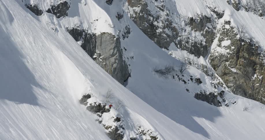 A person skis down a large rocky mountain side