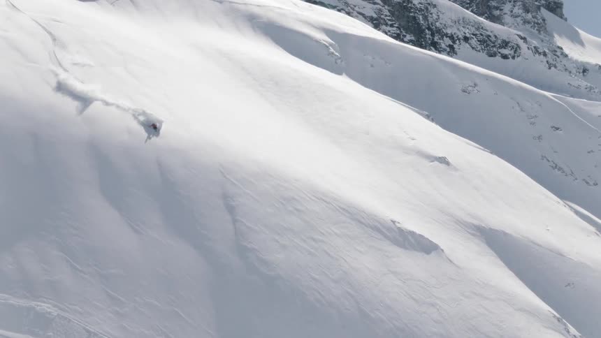 A skier moves quickly down a very steep mountain slope