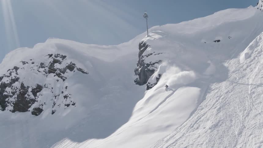 A skier is skiing down an extremely steep part of a mountain