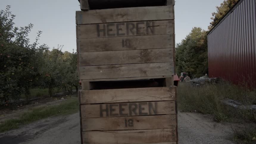 A tractor pulling three boxes stacked upon each other