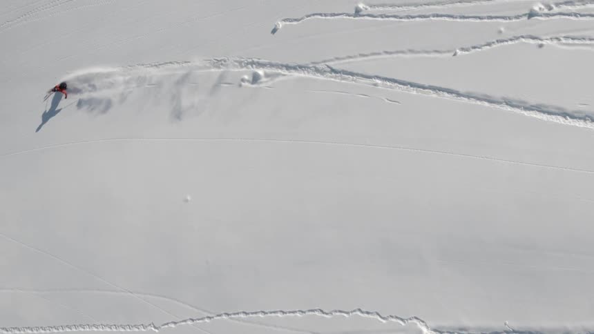 A person skis down a snow covered hill
