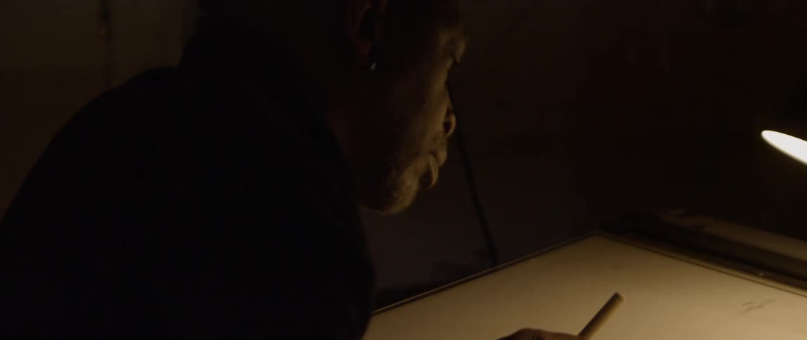 A woodworker chiseling and examining a block of wood