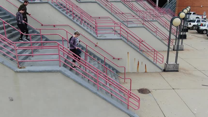 People walking down a flight of steps towards a parking lot
