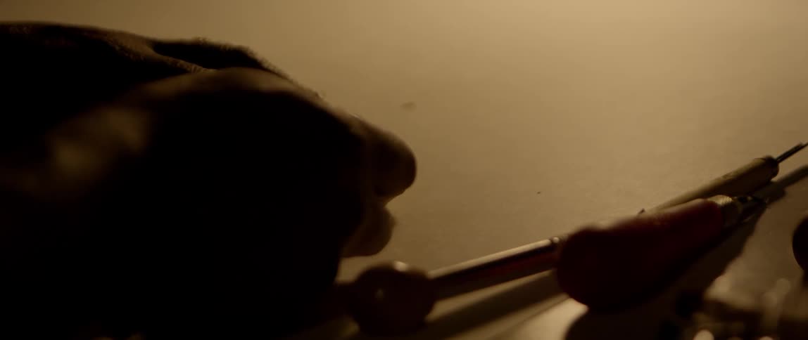 A person uses a tool to etch a design in wood