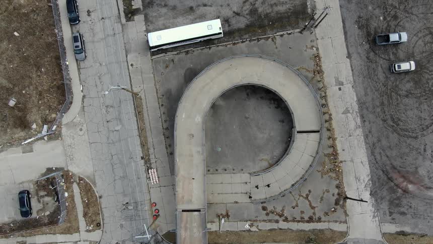 Three people run down a concrete ramp outdoors