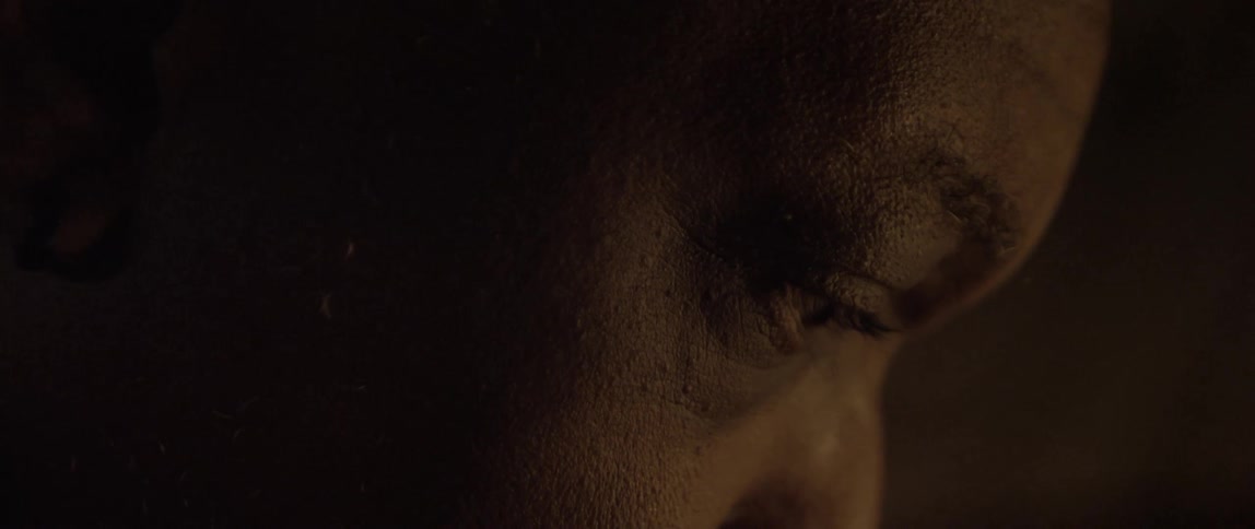 An african american man sits with his head bowed down