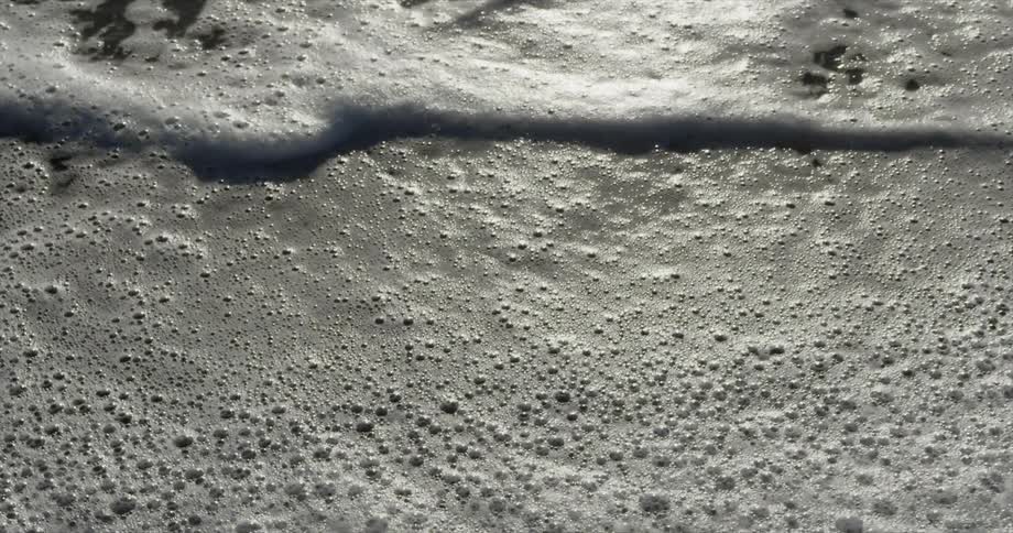 Bubbly waves flow up to the beach