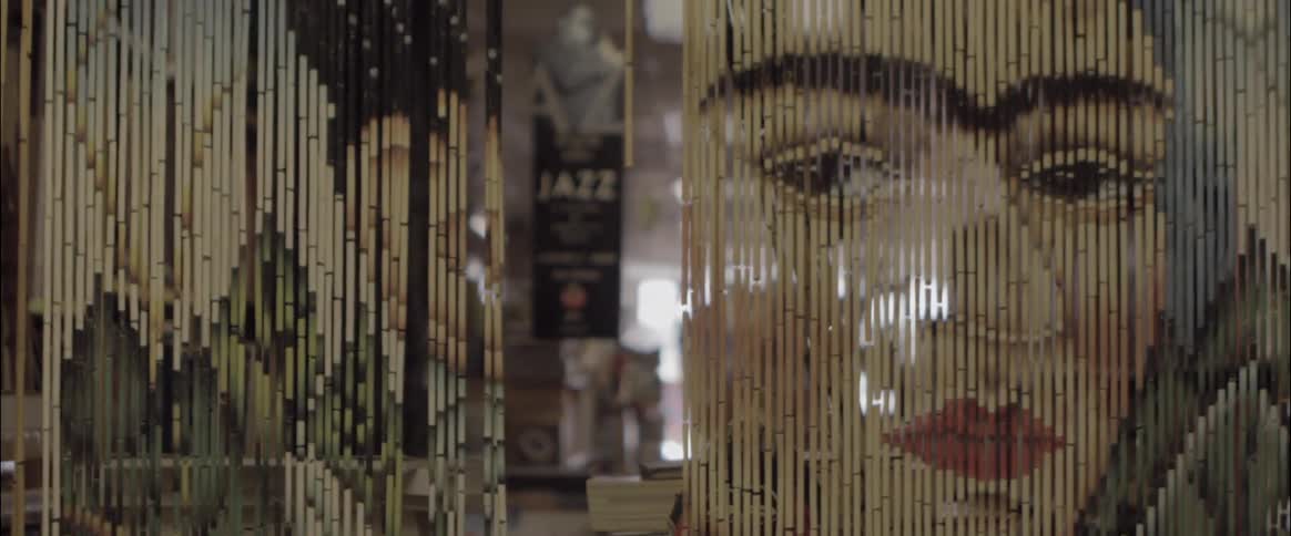 A painted art piece of frida kahlo on a bamboo curtain