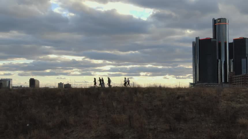 A group of people are jogging near the city skyline