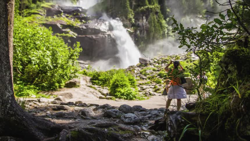 Tourist viewing waterfall in tropical forest