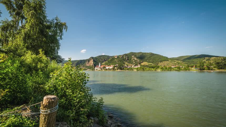 Timelapse of a day on the shore of a calm river