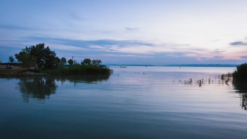 Time lapse of calm waters on a lake at dawn