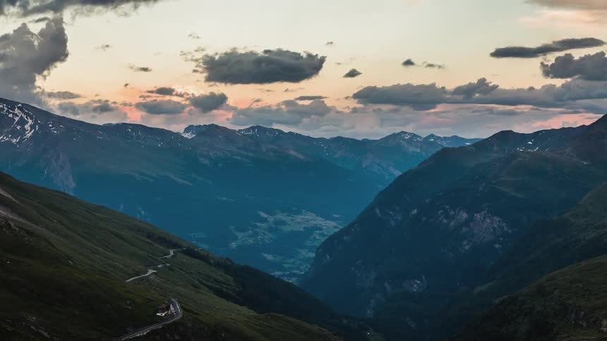 A large mountain range with a road winding across
