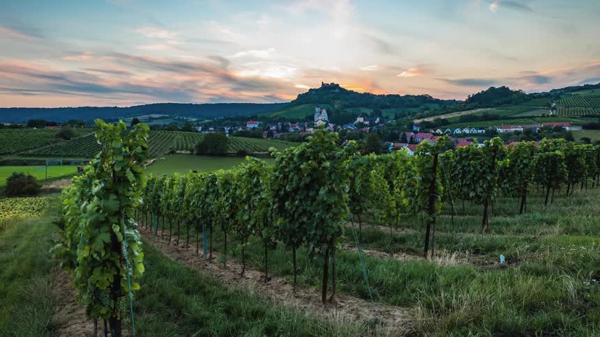 Timelapse of crops and rolling hills near a small town