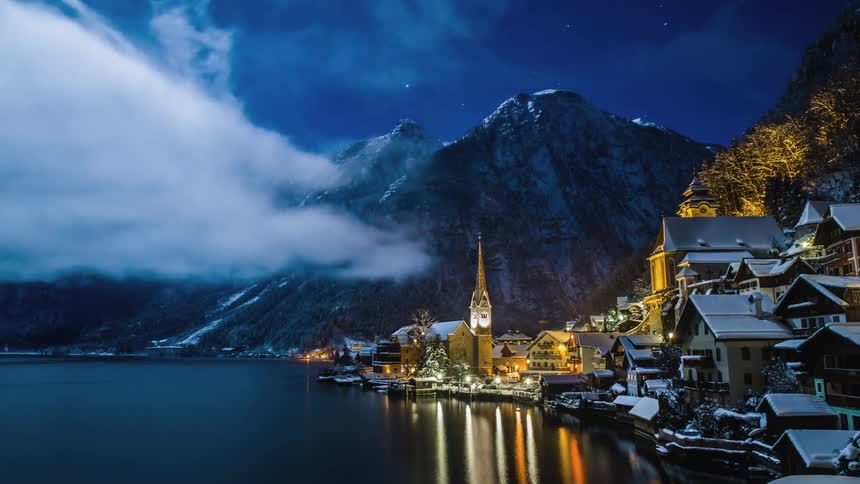 A densely packed town sits between mountains and a body of water