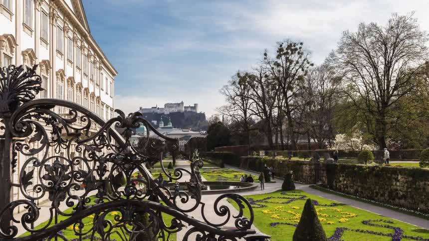 People walk in a park near the old building