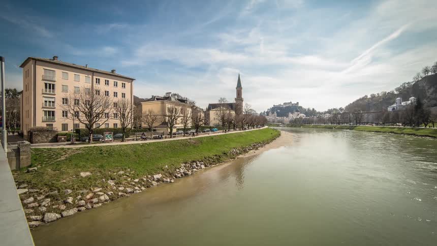 A muddy river surrounded by grass and village buildings
