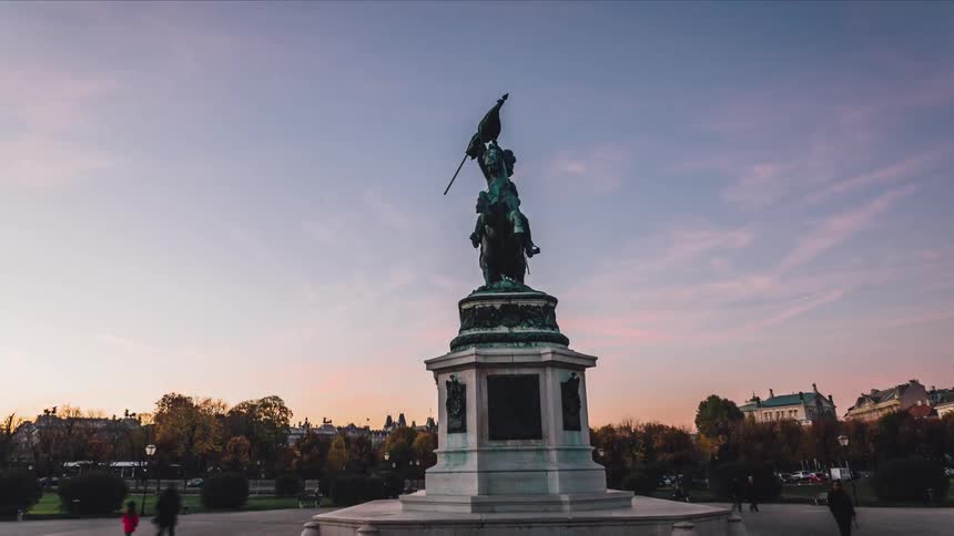 An old statue sits in the plaza of an old building