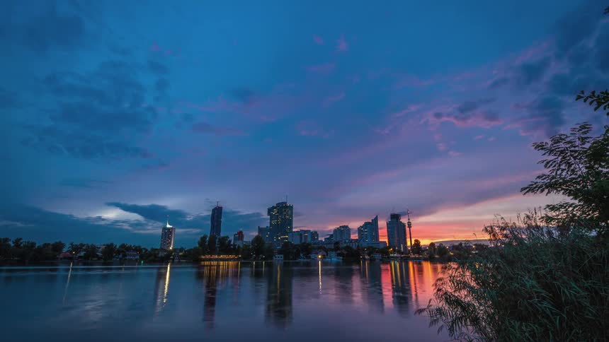 Sailboats clouds and water rippling on a time lapse of a waterfront metropolis